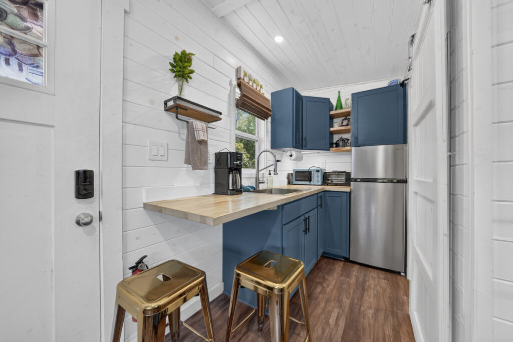 Kitchenette with counter seating — fridge, freezer, microwave, coffee maker